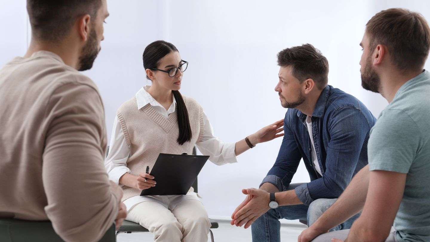 Group therapy session, where therapist discusses the ego in recovery with clients. 