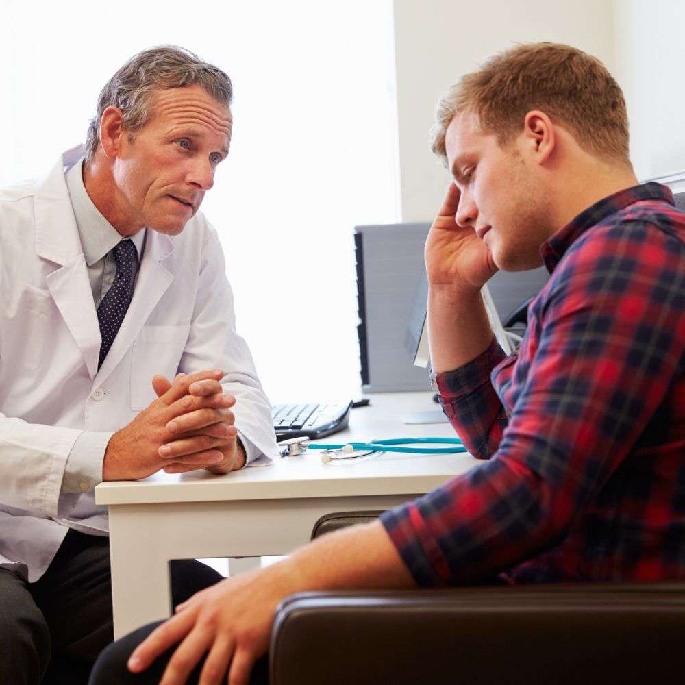 A man discusses his medical history with his doctor during a consultation for drug rehab for men.