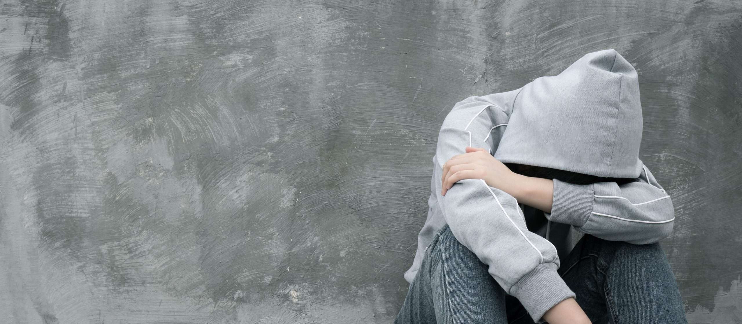 person in gray hoodie looking withdrawn